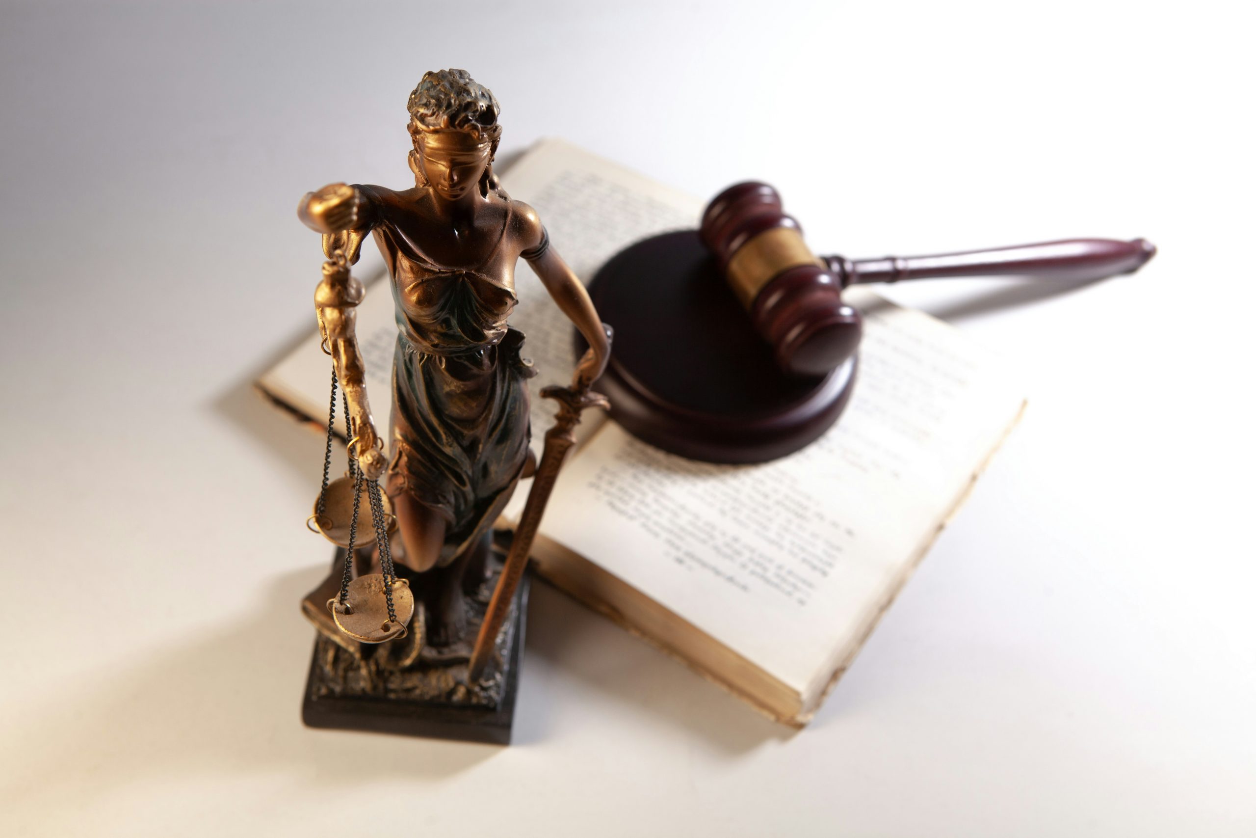 law book, lady justice statuette, and gavel